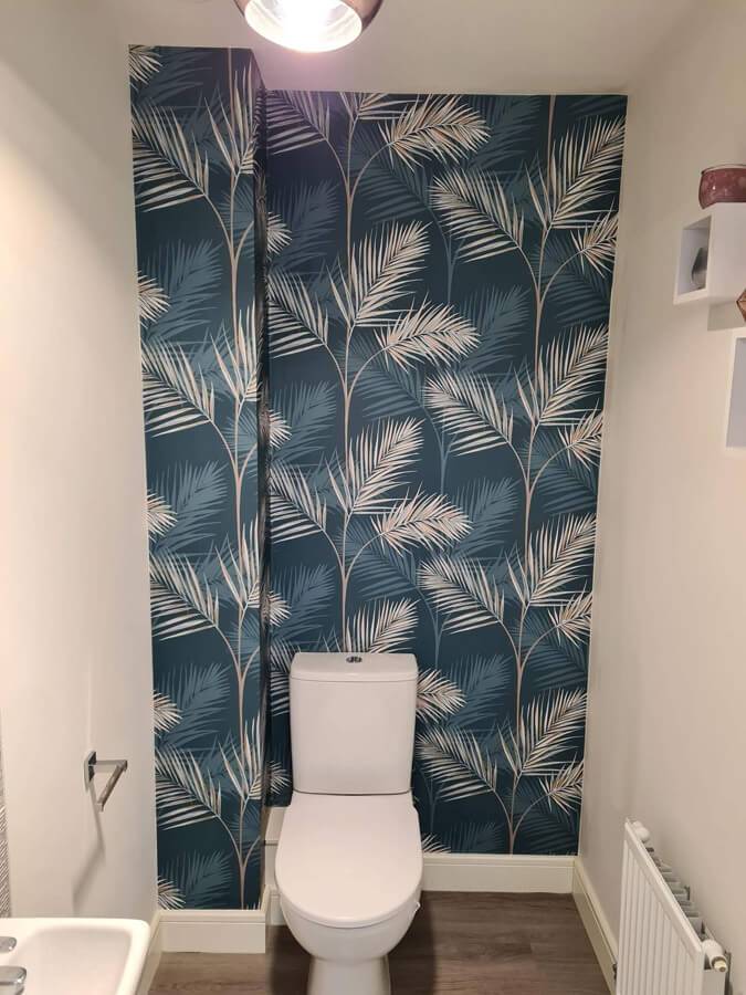 patterned wallpaper above toilet